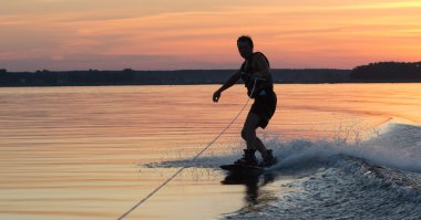 Wakeboarder günbatımı üzerinde hileler yapmak