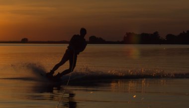 Wakeboarder günbatımı üzerinde hileler yapmak