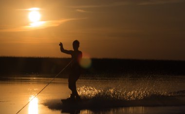 Wakeboarder günbatımı üzerinde hileler yapmak