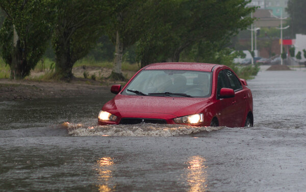 car rides in heavy rain on a flooded road