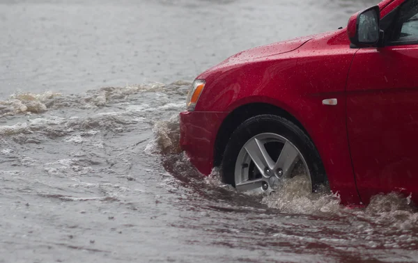 Автомобіль їде під сильним дощем на затопленій дорозі — стокове фото