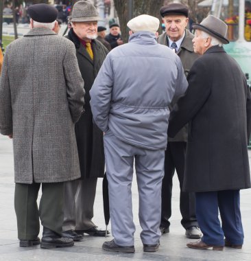 Ukrayna. Lviv - 15 Kasım 2015: Aktif emeklilik, Grup Eski erkek arkadaşıyla konuşuyor ve Lviv, Ukrayna genel parkta bankta gülüyor