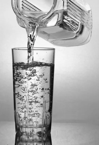 물 잔에 물을 붓는 — 스톡 사진