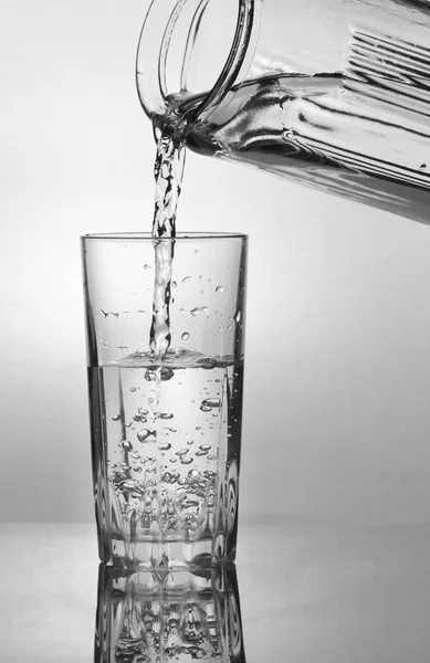 Menuangkan air ke dalam gelas air — Stok Foto