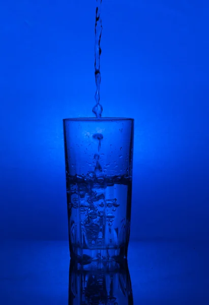 Pouring water into Glass of water — Stock Photo, Image