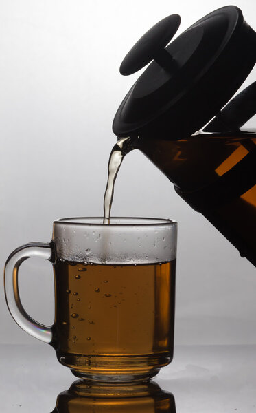 Pouring tea into cup of tee