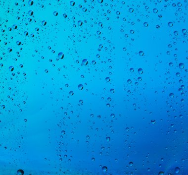 Su damlalarının arka planı cama düşer