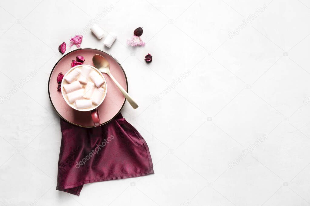 Mug with hot coffee and marshmallows on a pink plate on a gray background, horizontal orientation, flat lay