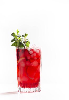 Beyaz arkaplanda buzlu, naneli ve limonlu kırmızı çay, yakın plan, kopyalama alanı, dikey yönelim 