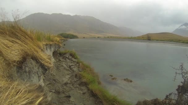 Moucha rybář náhodně děsí nebo chybí ryba při odlévání na řece Ahuriri na mokrém dni na Novém Zélandu