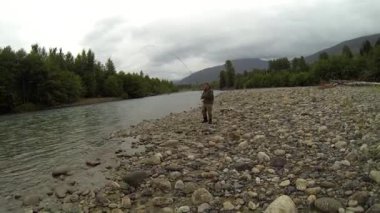 Adam Kanada 'da Kitimat Nehri' nde balık tutarken somon yakalıyor..