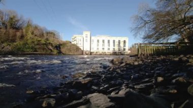Tongland 'daki Dee Nehri' nin arka planında Kirkcudbright yakınlarındaki elektrik santrali, İskoçya 'daki Galloway Hidroelektrik şeması,