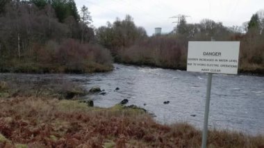 Kendoon Elektrik Santrali, Galloway Hidroelektrik Şeması, İskoçya 'da Ken' in suyunun yanında hızla akan tehlike işareti