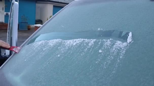 寒い冬の朝に凍った風の盾や車の画面から氷を削る男 — ストック動画