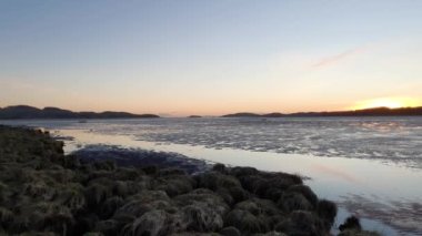 Kirkcudbright körfezi ve Dee haliçleri gün batımında Manxman Gölü 'nde bir kış günü, Ross Adası ve uzakta deniz feneri, Galloway, İskoçya