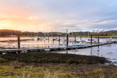 Kışın Kirkcudbright marinası ve limanı üzerinde gün batımında, gemiler demirli, Dumfries ve Galloway, İskoçya