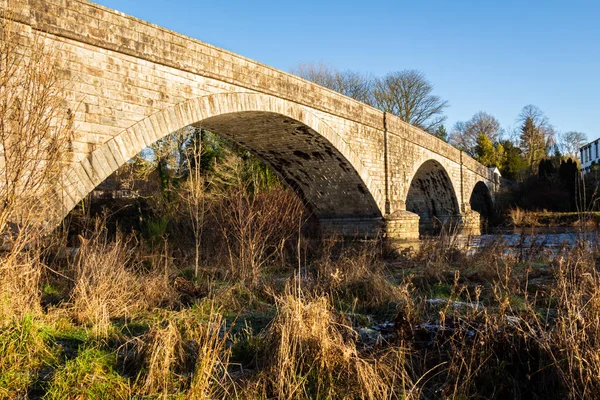 The arched Ken Bridge over the Water of Ken on a sunny winters day, with frost on the ground New Galloway, Dumfries and Galloway, Scotland