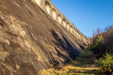 Clatteringshaws Barajı 'nın kemerli mimarisi, Galloway Hidroelektrik Şeması' nın yerçekimi barajı, İskoçya