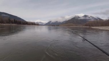 Bahar mevsiminde Skeena Nehri 'nde somon avlamak için sinek avlamak, dağlarda kar, Britanya Kolumbiyası, Kanada