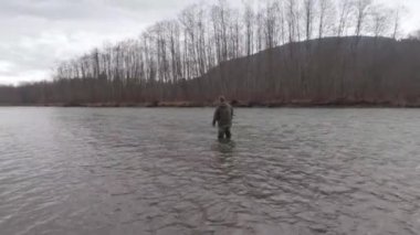 Skeena Bölgesi, Britanya Kolumbiyası, Kanada 'da bahar aylarında balık ve çelik kafa avlamak için nehre dökülen bir adam.