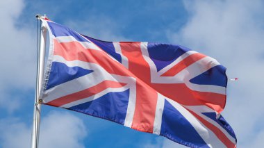Gökteki bayrak direğinden dalgalanan bir İngiliz bayrağı, Büyük Britanya Birleşik Krallığının ulusal bayrağı.