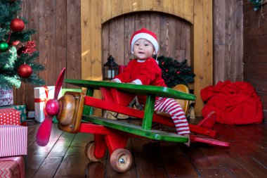 Noel Baba kostümlü küçük çocuk tahta bir uçakta..