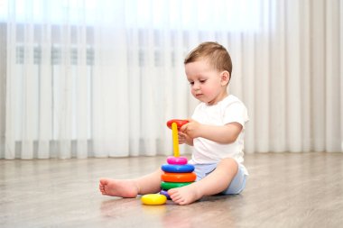 Oyun odasında mavi gözlü küçük bir çocuk oynuyor..
