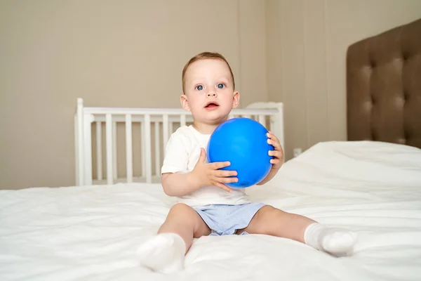 一个蓝眼睛的小孩拿着一个球 — 图库照片