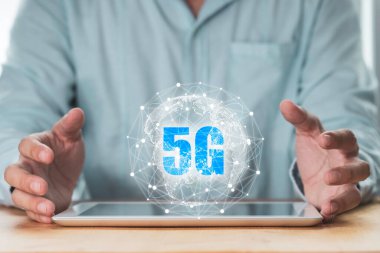 5G ve şeyin interneti veya IOT konsepti, iş adamı tablet üzerinde sanal 5G küresel ağı koruyor.