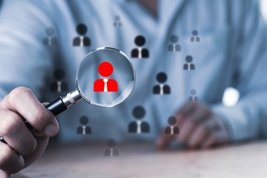 İnsan gelişimi ve istihdam konsepti, iş adamı büyüteç kullanarak düzgün bir çalışanı arıyor..