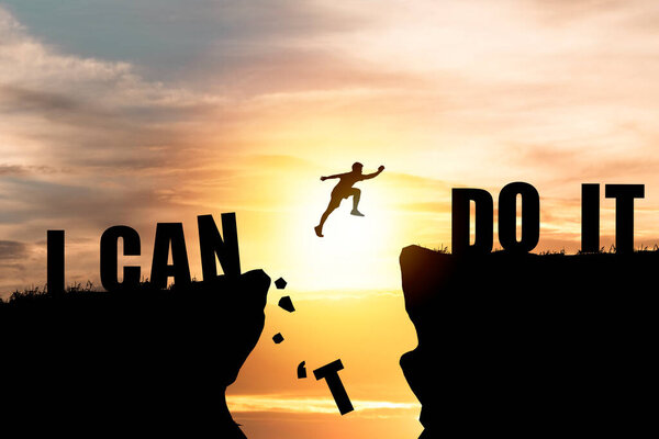 Silhouette man jumping over cliffs for I can do it , good mindset by never give up concept.