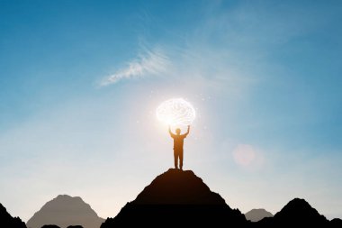 Silüet adam elini kaldırdı ve mavi gökyüzü ile dağın tepesinde sanal beyni tuttu. Akıllı düşünce ve fikir kavramı.