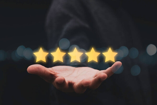 Бизнесмен показывает пять звезд под рукой для оценки клиента результат. Удовлетворение потребностей клиентов в продуктах и услугах.