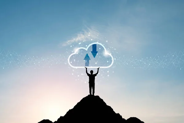 Cloud computing and technology transformation concept , silhouette of businessman standing and two rise hand up for holding virtual cloud computing on the top of mountain.