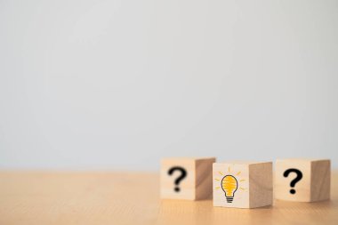 Tahta blok küpte illüstrasyon ampul simgesi ve soru işareti yazdırma ekranı. Yaratıcı düşünce ve yenilik kavramı..
