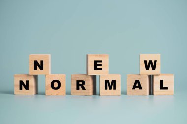 Şimdi mavi zemin üzerinde tahta küp blok üzerinde normal yazı ekranı COVID-19 salgın hastalık kavramı nedeniyle iş ve yaşam tarzı değişimi.