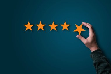 Mal ve hizmetin kalitesini değerlendirmek için el ele tutuşmak ve sarı yıldızlar koymak, müşteri memnuniyeti kavramı.