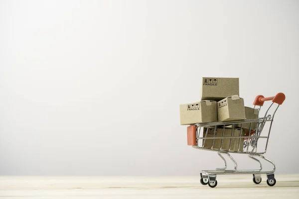 コピースペース ショッピングやコマースの概念とテーブルの上に赤いショッピングカートトロリー内の出荷紙ボックス — ストック写真