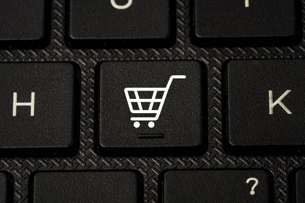 Düğme bilgisayarındaki bilgisayar klavyesi, online alışveriş ve e-ticaret konsepti üzerindeki beyaz Trolley veya alışveriş arabası simgesi yazdırma ekranı.