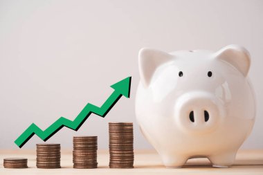 Para biriktirme ve mevduat kavramı için artan yeşil okla dolu beyaz kumbaralar ve madeni paralar..