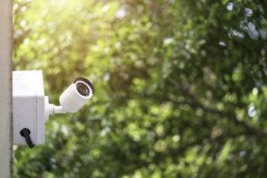 Beyaz Kapalı Devre Televizyonu veya yeşil ağaçların arka planına sahip CCTV, CCTV güvenlik görevlisinin suç oranını izlemesine ve önlemesine yardımcı olacak.