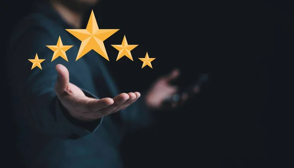 顧客満足と製品サービス評価の概念のために手に黄色の星を保持ビジネスマン — ストック写真