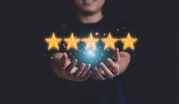 顧客満足と製品サービス評価の概念のために手に黄色の星を保持ビジネスマン — ストック写真