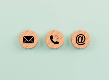 E-posta adresi, telefon numarası ve harf simgeleri, web sayfası iş kişisi ve müşteri hizmetleri konsepti için yeşil zemin üzerinde yuvarlak tahta blok üzerine 3D görüntüleme ekranı yazdırır.