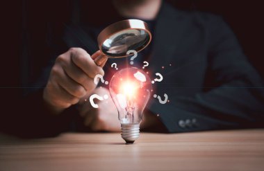 Büyüteçle, parlayan ampulleri ve soru işaretlerini analiz ederek iş sorunları çözme kavramı. Yenilik araştırması, yaratıcı düşünme, çözüm keşfi ve stratejik karar verme.