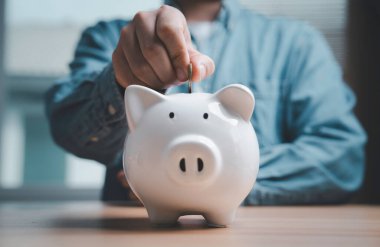 İşadamı, daha fazla kar ve kâr elde etmek için kumbaraya, kişisel finans planlamasına, bütçe stratejisine, zenginlik büyümesine ve mali güvenliğe para, tasarruf ve yatırım konsepti koydu.