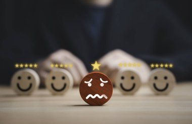 Müşteri memnuniyeti ve geri bildirim değerlendirme konsepti. Mutlu reytingler arasında mutsuz yüz ikonu da var. İş hizmeti kalite değerlendirmesi, müşteri deneyim analizi ve itibar yönetimi.