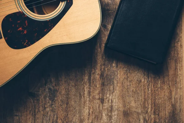 Una Guitarra Una Biblia Sobre Fondo Madera Ambiente Débilmente Iluminado —  Fotos de Stock