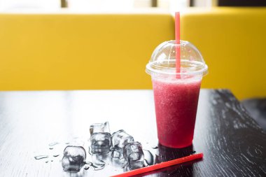 Kafedeki ahşap bir masada kırık buzlu meyveli kokteyl. Ezilmiş buzlu çilek kokteyli. Bir şeyler içeriz. Boşluğu kopyala