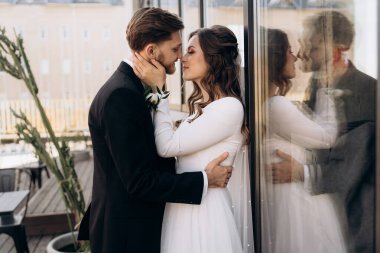 Düğün günü. Avrupalı şık bir düğün çifti sarılıyor ve birbirlerine bakıyor. Gülümseyen gelin peçeli beyaz bir gelinlik giyiyor. Siyah takım elbiseli bir damat..